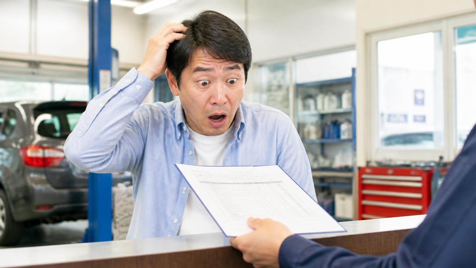 修理費は幅が大きすぎる|整備工場のカウンターで見積書を渡された男性1人が金額を見て言葉を失う