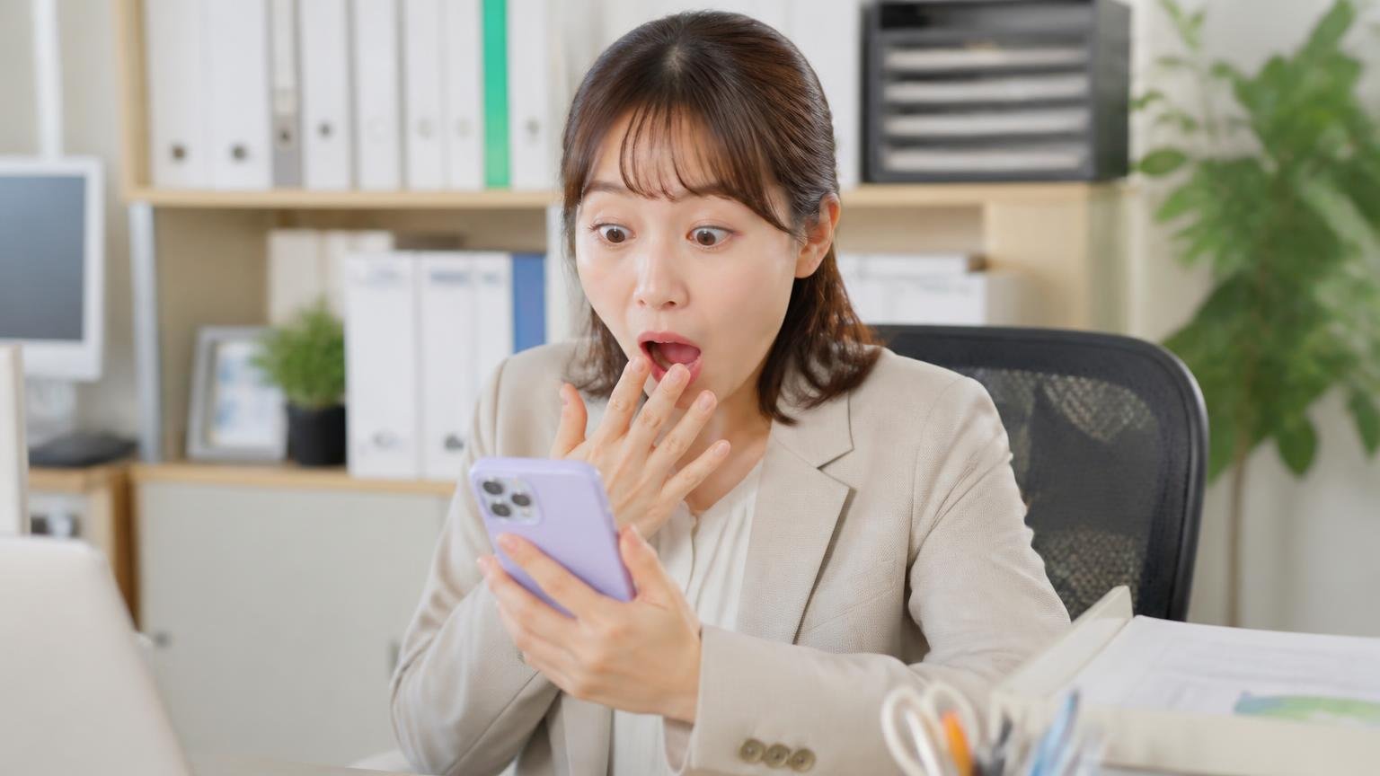 Googleマップは★3.9、20件のうち半分が★5 事務所の机でスマホの口コミ画面を見る女性1人、星の数に目を丸くして驚く