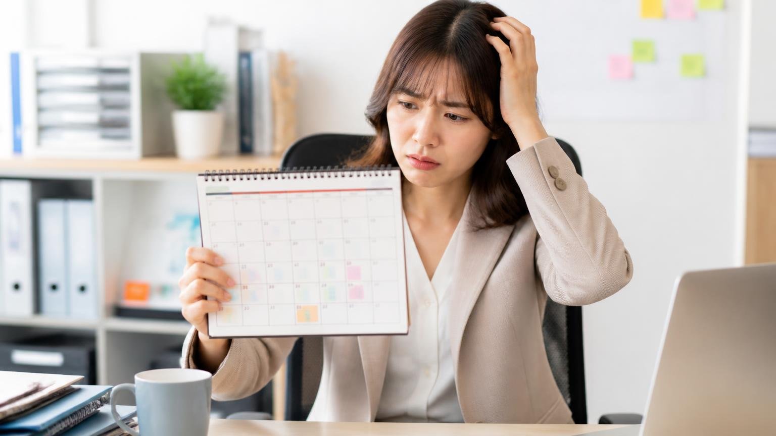 向いていない人は3エリアから遠い人や平日に動けない人。事務所で女性がカレンダーを見ながら困った表情を見せる