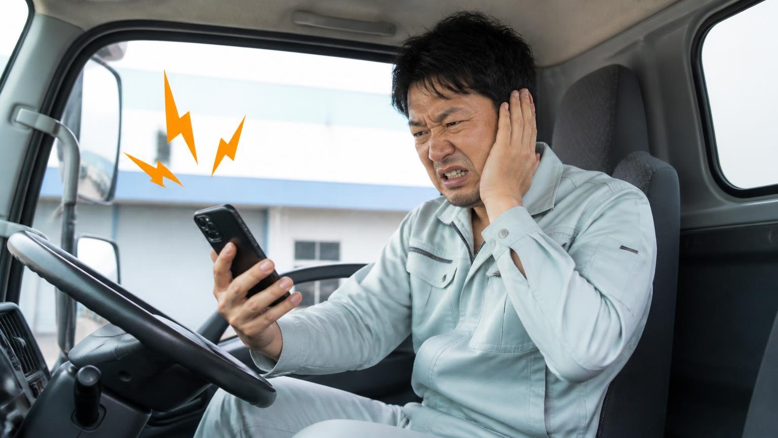 「営業電話がしつこいのは嫌」は申し込むときの一言で防げる|トラックの運転席で鳴り続けるスマホを見てうんざりする作業着の男性1人