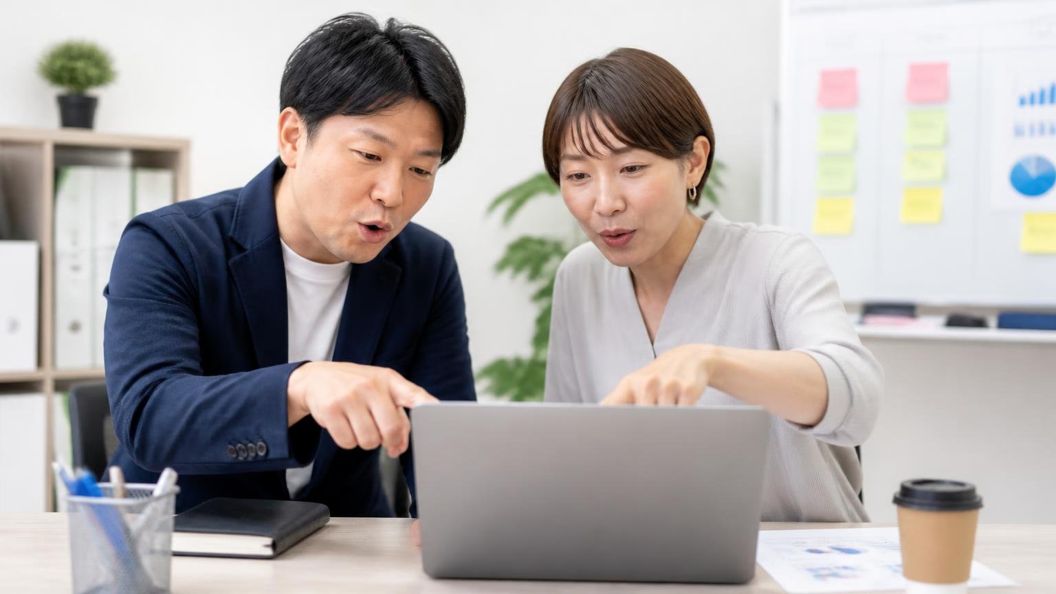 口コミを3分類して読む。事務所でノートパソコンの口コミ一覧を、男女2人が指で分けながら確認する