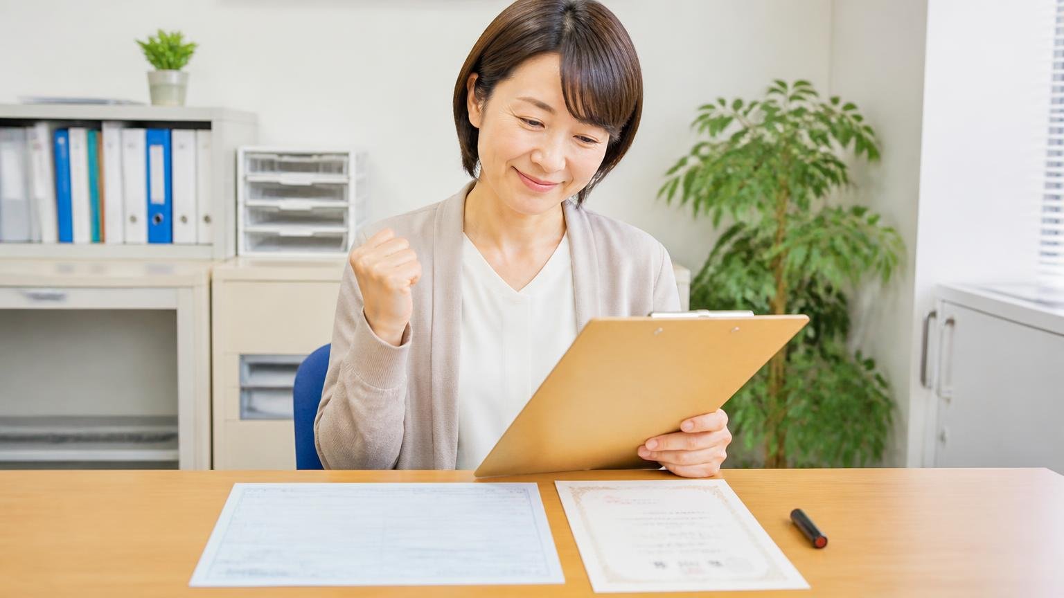 名義変更(移転登録)で売る側が用意する書類 事務所の机に車検証と印鑑証明書と実印を並べる場面 事務担当1人 チェックリストを確認し安堵の表情